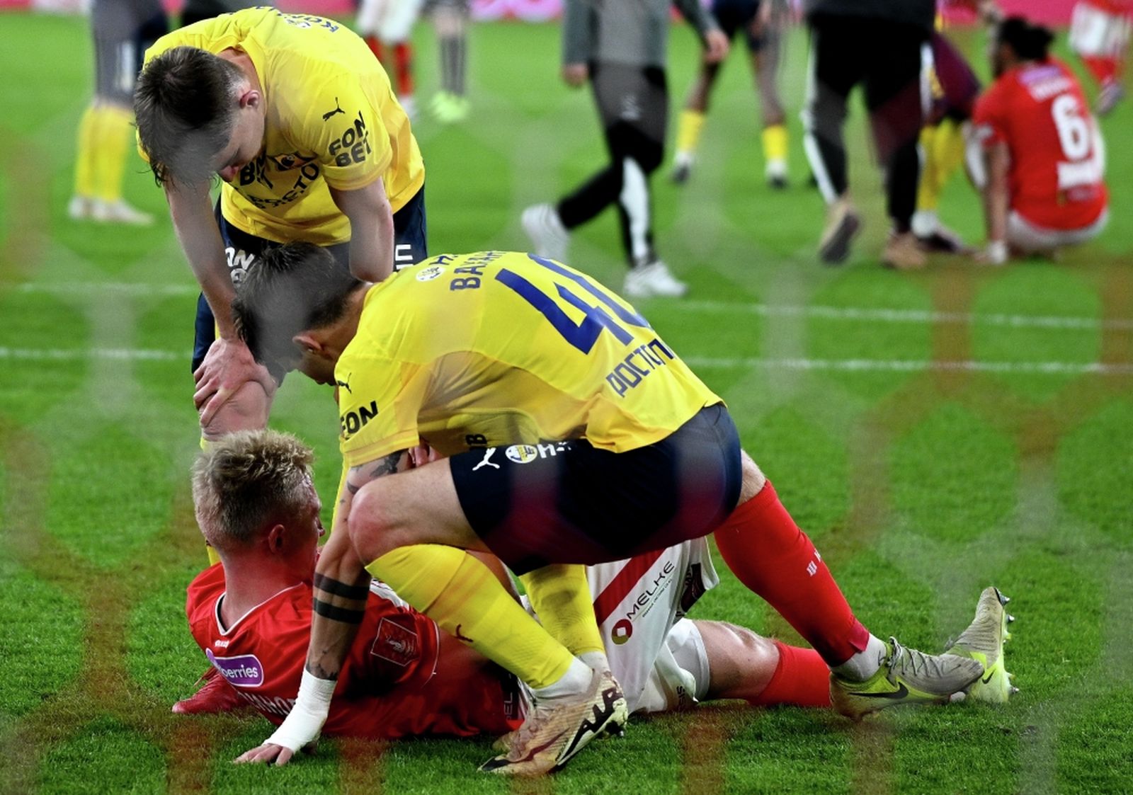 15 мая 2025 года. Футболисты «Ростова» Иван Комаров и Илья Вахания возле подвернувшего ногу игрока «Спартака» Руслана Литвинова в матче FONBET Кубка России. Фото: Алексей Филиппов / РИА Новости ©